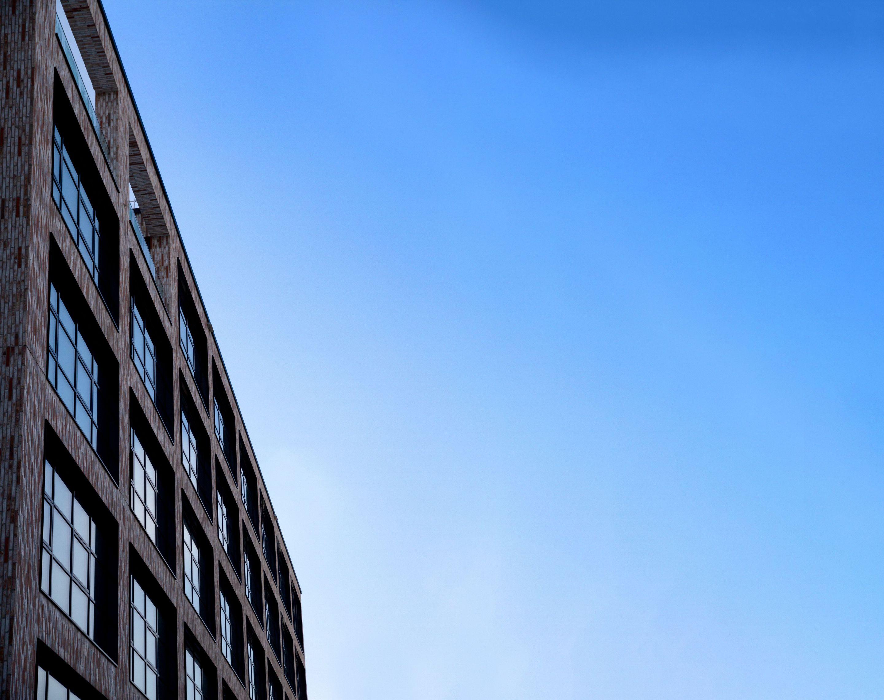 Moderne Fassade des Neue Siederei Gebäudes vor blauem Himmel.
